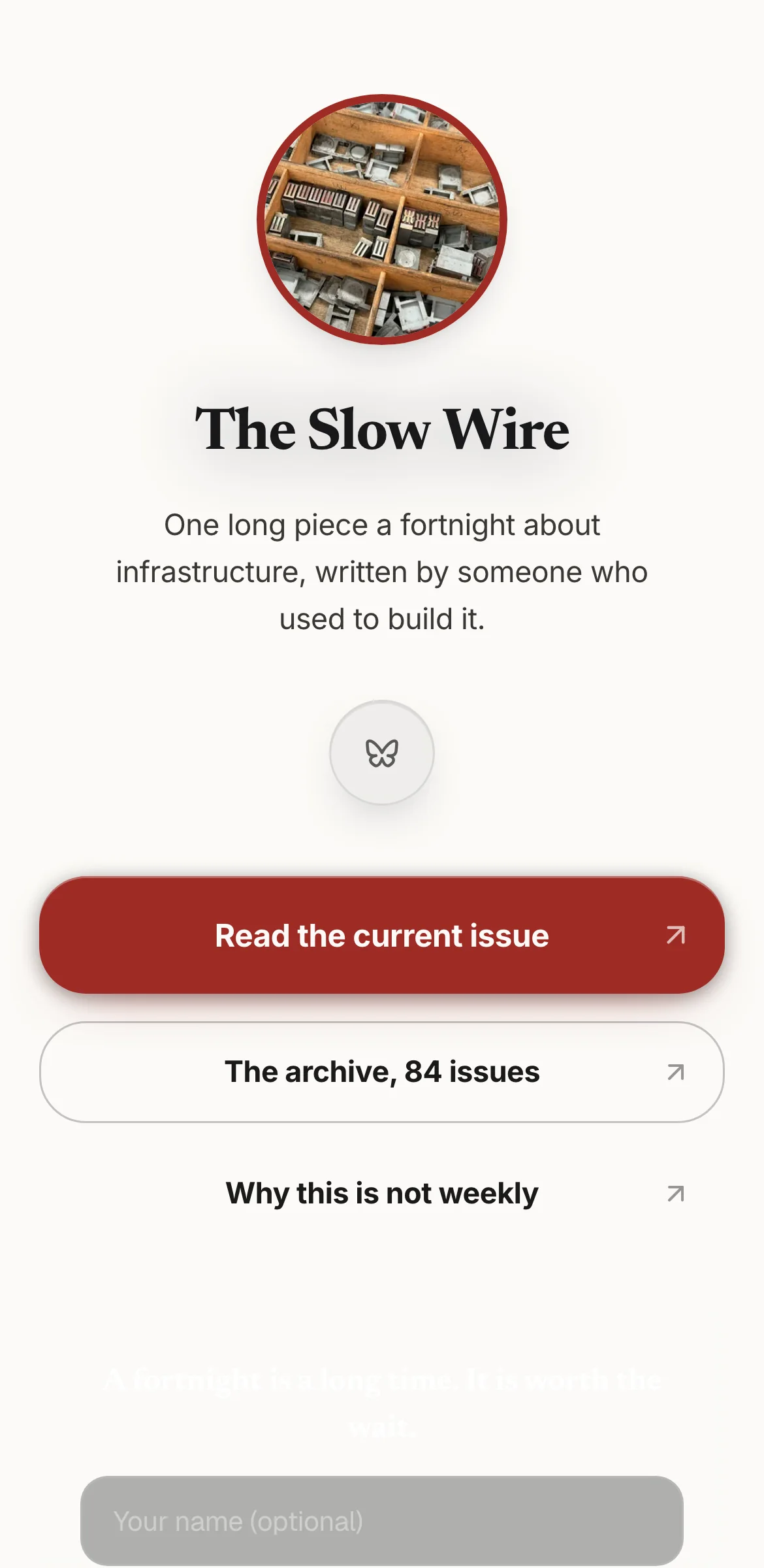 Example link in bio page for a fictional newsletter, The Slow Wire: white page, type-drawer photo in a red ring, brick red Read the current issue button.